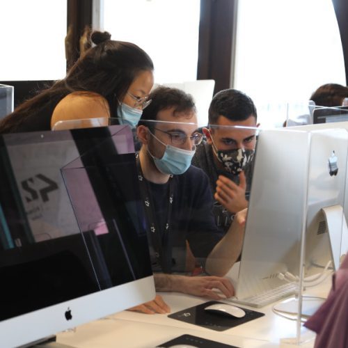 3 students (2 men and 1 woman) working together on an iMac - 42 Roma campus (Italy)