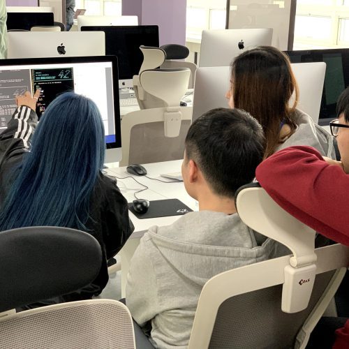 Small group of students working together from behind on an iMac - 42 Seoul campus (South Korea)