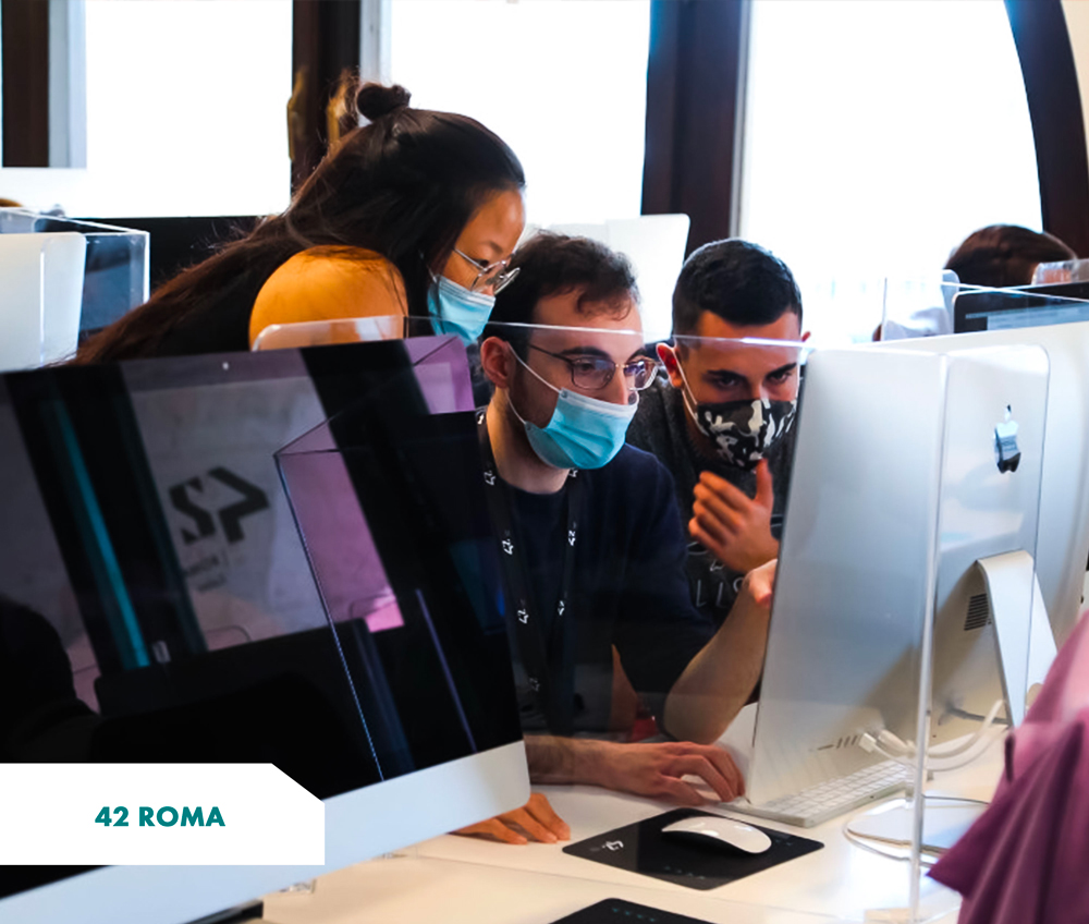 3 students (2 men and 1 woman) working together on an iMac - 42 Roma campus (Italy)